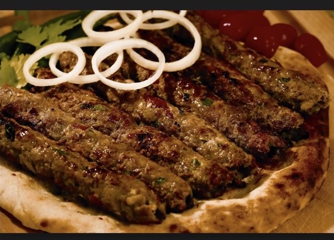 Royal Delight Seekh Kabobs served over fresh naan with onion and chutney